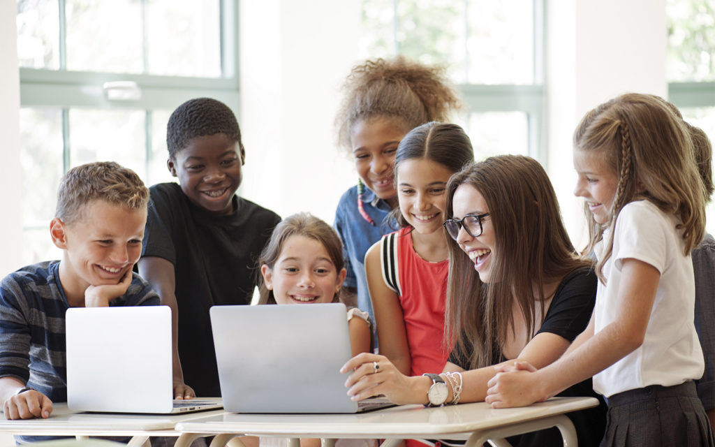 hero-teacher-with-students-on-laptop
