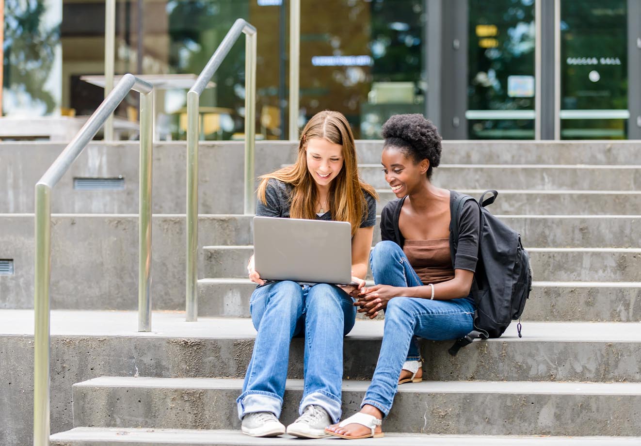 University-students-sitting-on-stairs-with-laptop