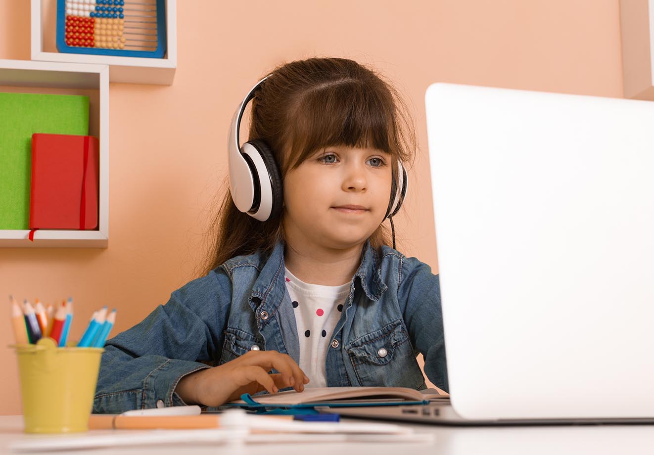 Young girl using laptop and headphones