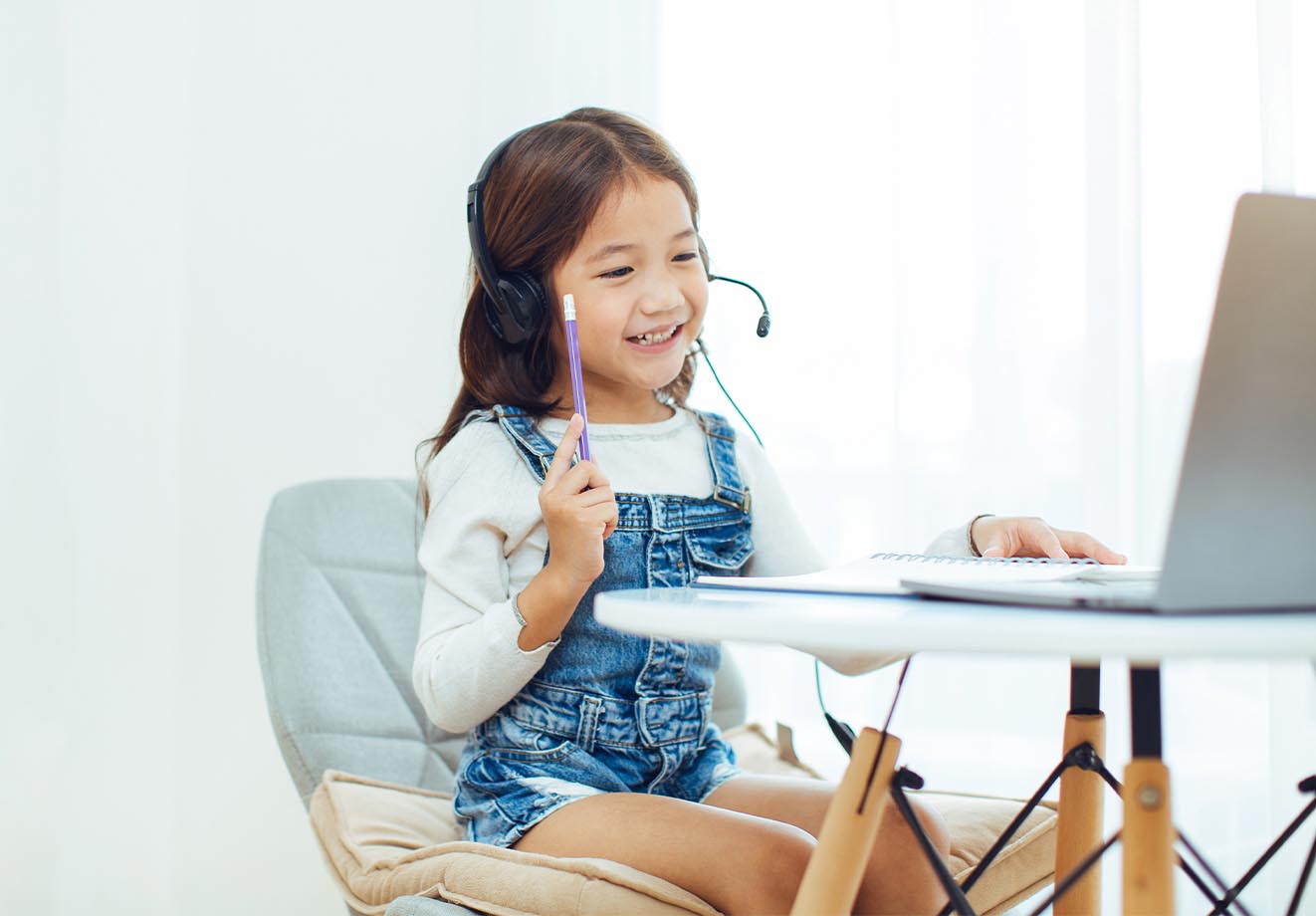 girl wearing headphones and working on her laptop