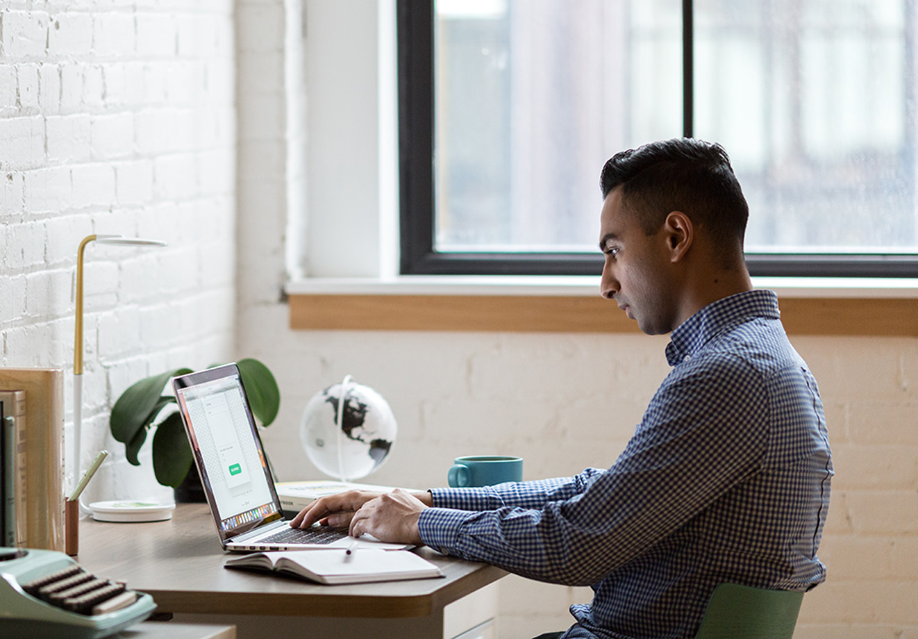 man at desk using laptop