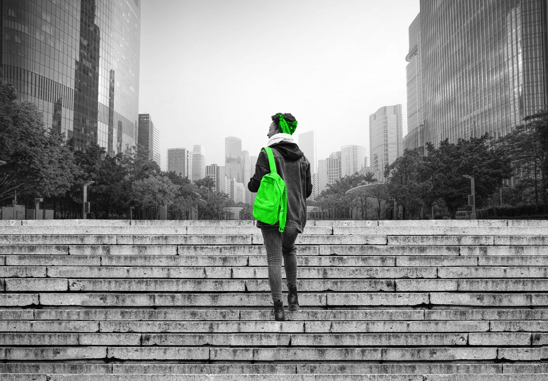 A nontraditional student walking up stairs in a city.