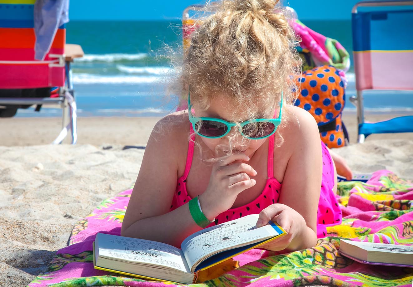 girl reading on the beach