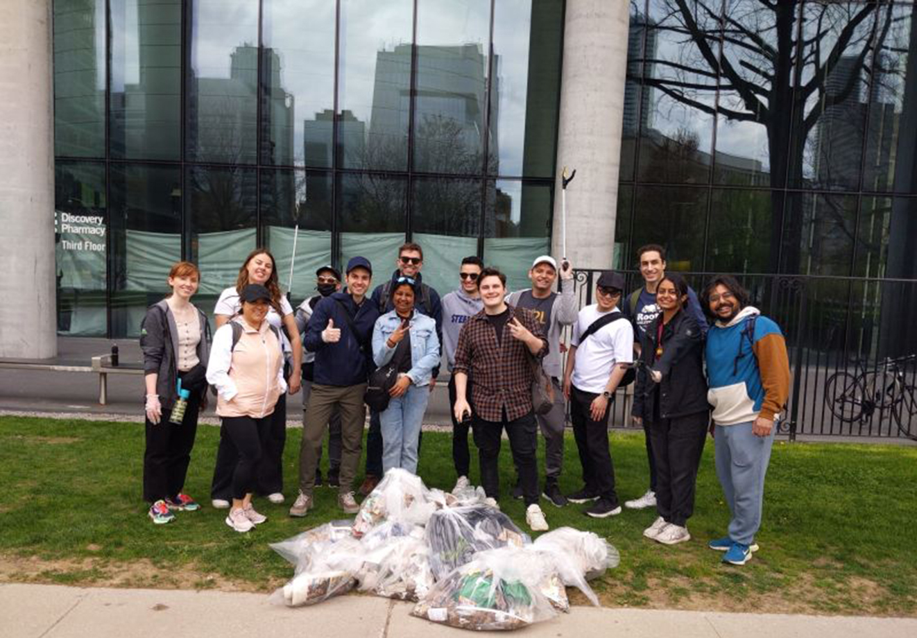 A group of D2Lers standing outside of office with piles of collected garbage in front of them