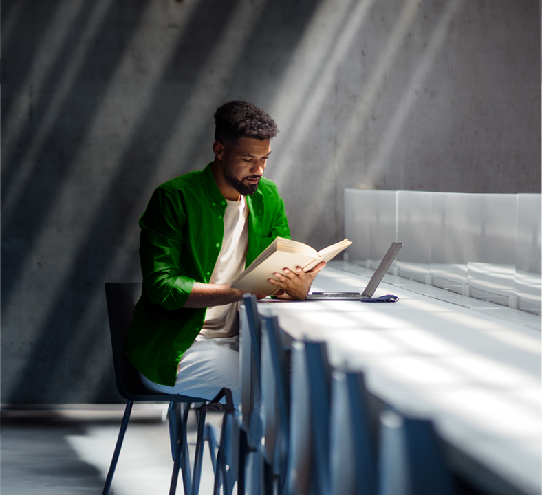 Teacher working at table with laptop
